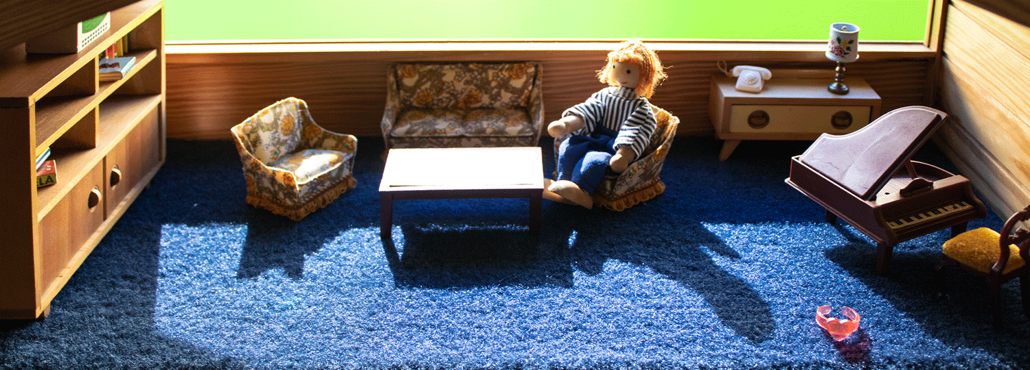 Bild für Kontakt , Püppchen im Wohnzimmer sitzend, Praxis für systemische Jugend- und Familienhilfe